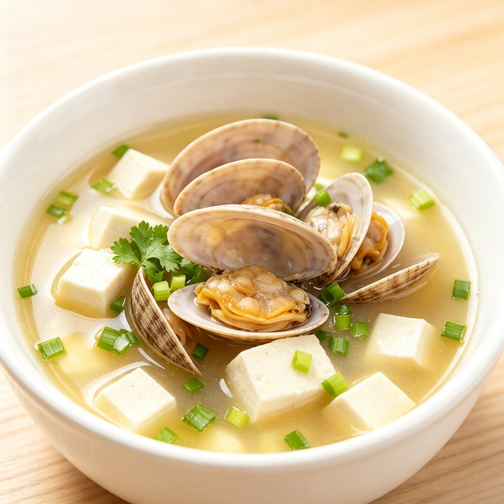 Clam and tofu soup garnished with coriander and spring onion