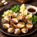 Raw spotted babylon snails on crushed ice with lemon and herbs