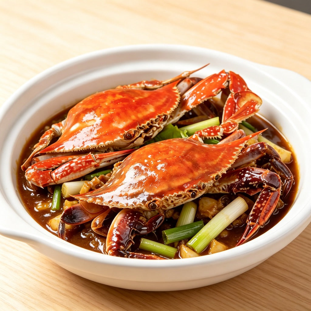 Cooked swimming crab in a savoury sauce with spring onion in a white bowl